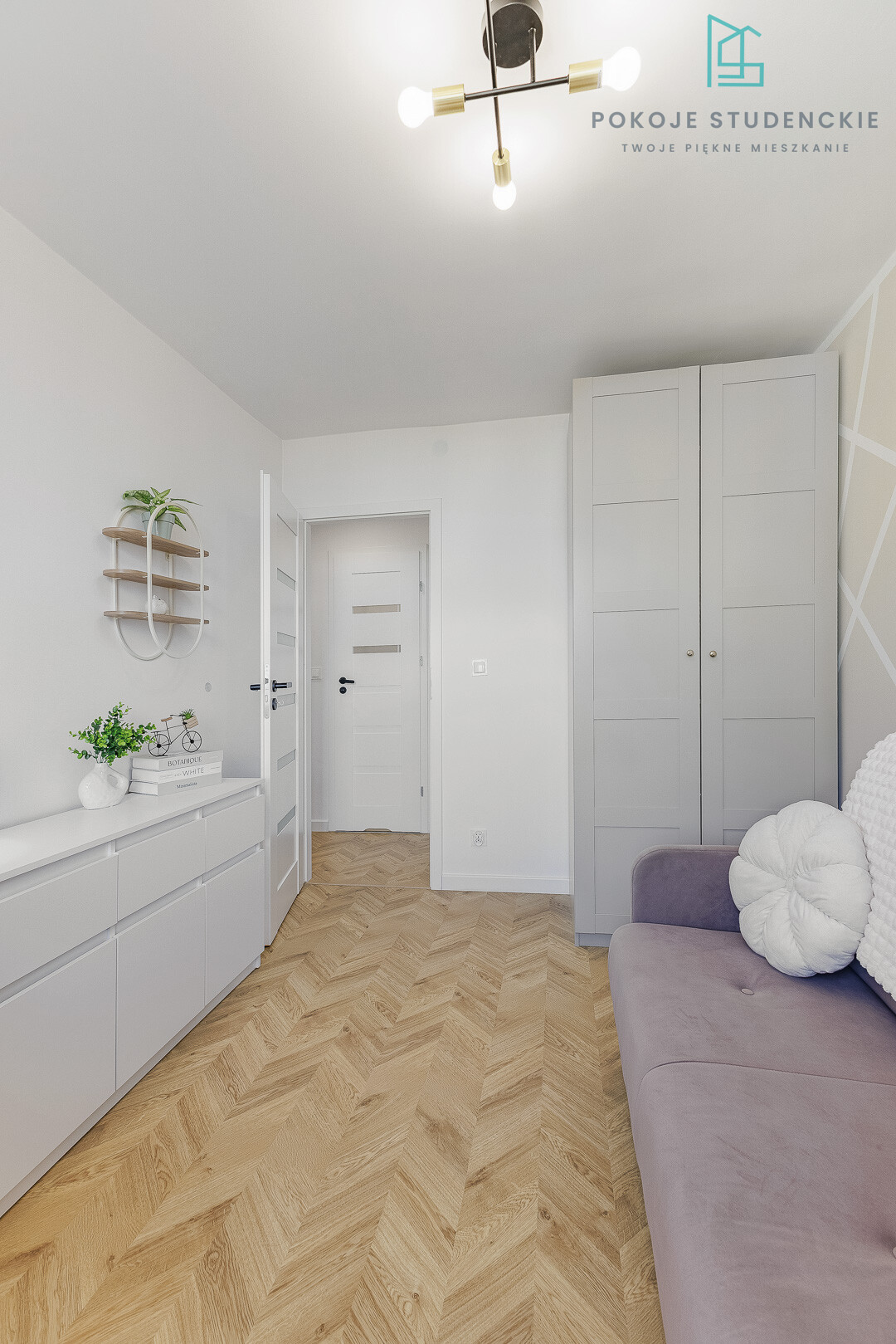 Bright modern dorm room interior with white cabinetry along the left wall, tall gray wardrobe, purple sofa, and a herringbone wood floor.