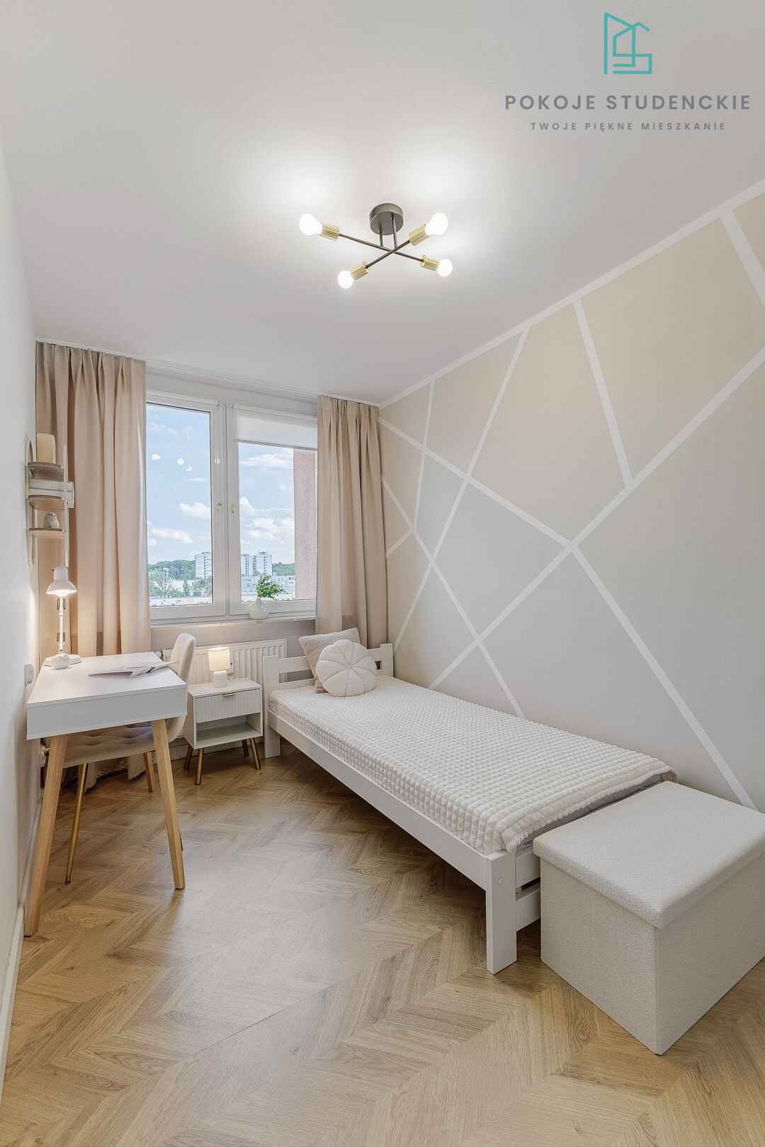 Small bedroom with a single white bed, geometric beige wall, and light wood desk near a window with beige curtains. A cozy, modern dorm-style room featuring a white desk, chair, and a bed against a patterned wall. Single bed setup with a white waffle-textured cover, geometric wall design, and a desk by the window. Bright, minimalist bedroom: white furniture, pale beige curtains, and a diagonal geometric wall pattern. Desk area and bed in a compact room with warm wood flooring and soft ambient lighting by the window.