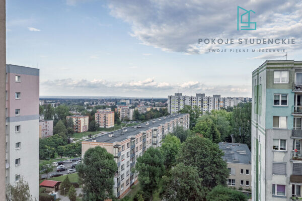 Aerial view of a city with many apartment blocks and trees; overlay logo 'POKOJE STUDENCKIE' in the upper right corner.